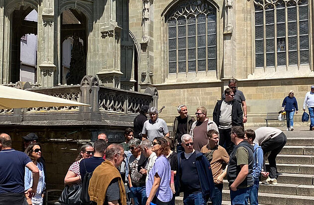Mitarbeiter der Zemp AG warten vor einer Kirche auf dem Firmenausflug zum 160-jährigen Jubiläums.
