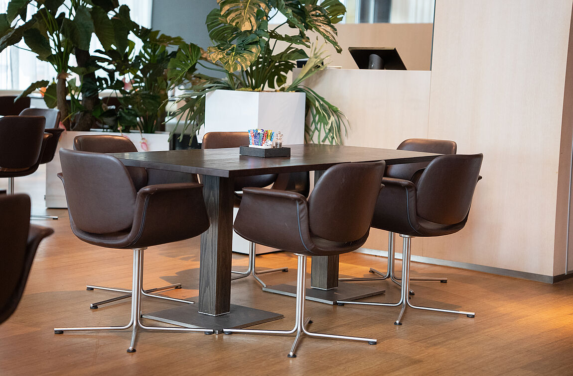 Eine Massivholz-Tischplatte mit quadratischem Tischgestell im Eingangsbereich des Radisson BLU.