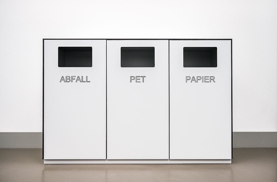Eine Recycling- und Abfall-Station für Abfall, PET und Papier in weiss.