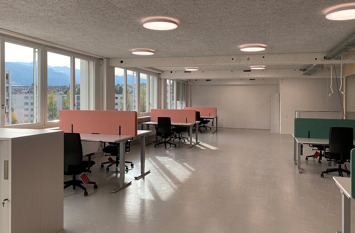 Desk-Sharing-Arbeitsplätze mit OPTIMO Steh-Sitztischen und Akustik-Sichtschutzwänden bei der IG Arbeit.
