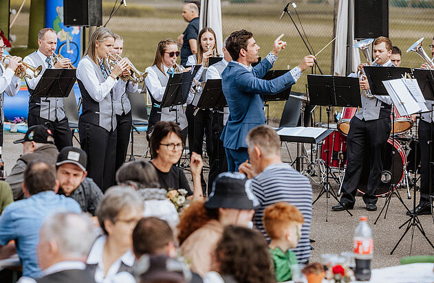 Ein Dirigent orchistriert eine Musikgruppe am Tag der offenen Tür.