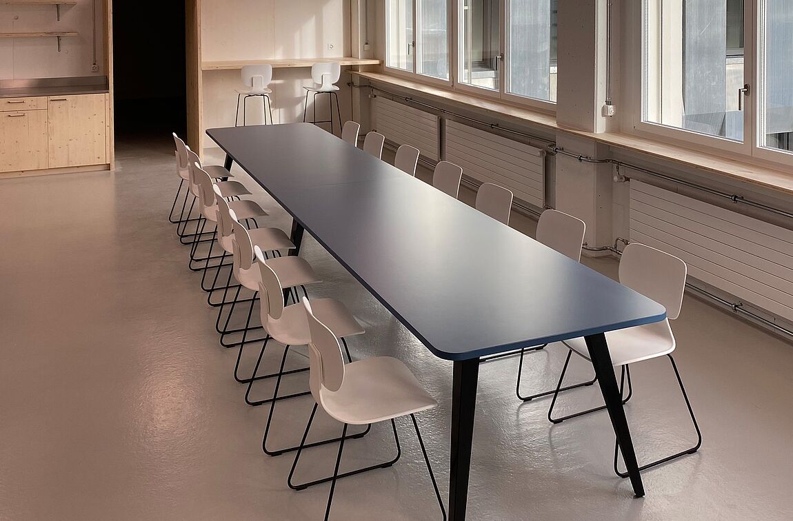 Ein grosser SPIDER Meetingtisch in blau im Pausenraum der IG Arbeit in Luzern.
