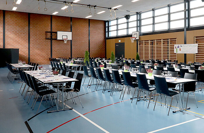 Mehrere TUBUS TK 22 Klapptische mit Atlanta Mehrzweckstühlen in der Mehrzweckhalle in Obergösgen.