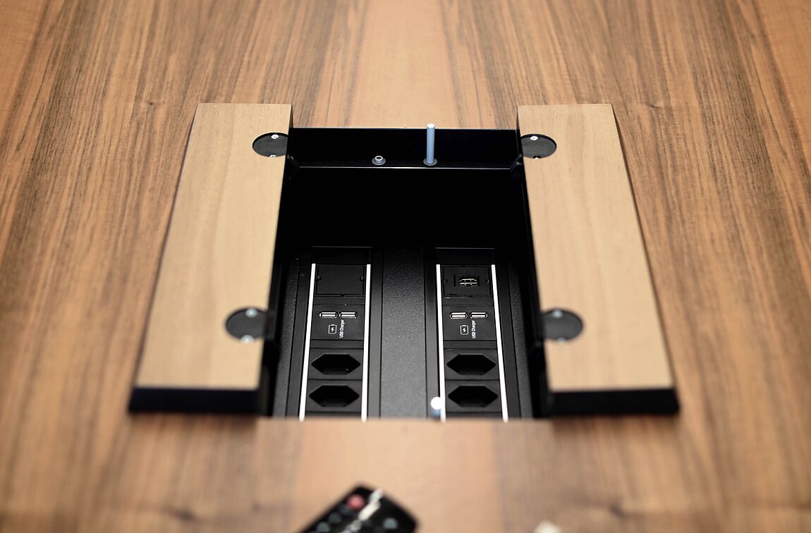 Ein geöffnete Elektrifizierungsbox verbaut in einen YPSILON Seminartisch.
