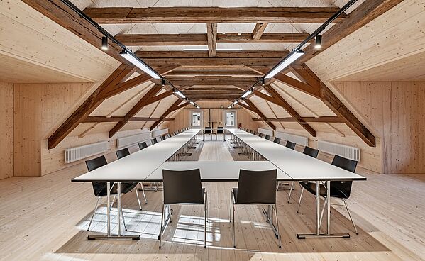 Diverse TUBUS-Klapptische mit stapelbaren Mehzweckstühlen im Mehrzwecksaal in Luzern.