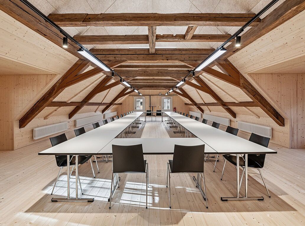 Diverse TUBUS-Klapptische mit stapelbaren Mehzweckstühlen im Mehrzwecksaal in Luzern.